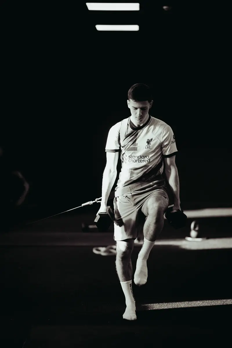 Loaded single-leg carry in a dimly lit gym