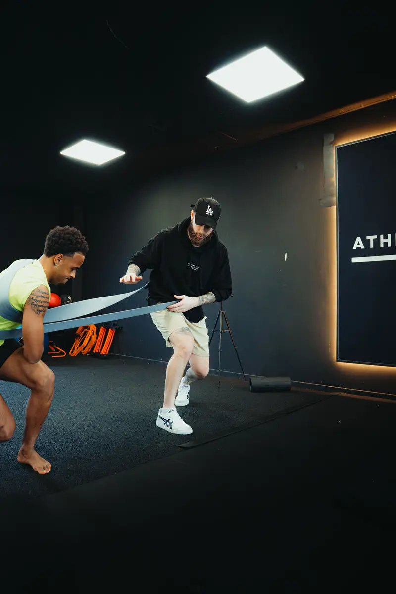 Coach working alongside an athlete in the gym
